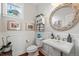 Charming powder room with decorative mirror and pedestal sink at 8256 E 28Th Dr, Denver, CO 80238