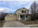 Charming two-story home featuring a welcoming front porch and an attached two-car garage at 335 Tynan Dr, Erie, CO 80516