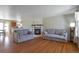 Cozy living room featuring a fireplace, hardwood floors, and comfortable sofas at 335 Tynan Dr, Erie, CO 80516