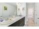 Bathroom with dual sinks, dark cabinets, large mirror, and easy access to a walk-in shower at 1190 Telleen Ave, Erie, CO 80516