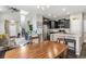 Open-concept kitchen featuring granite counters, stainless steel appliances, dark cabinetry, and a large wooden dining table at 1190 Telleen Ave, Erie, CO 80516