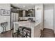 Well-appointed kitchen with granite countertops, stainless steel appliances, dark cabinets, and seating for two at the island at 1190 Telleen Ave, Erie, CO 80516