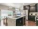 Kitchen island with stainless steel appliances, granite countertops, dark cabinets, and breakfast nook with backyard view at 1190 Telleen Ave, Erie, CO 80516