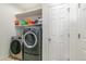 Functional laundry room featuring modern washer and dryer units, storage shelves, and a clean, organized space at 1190 Telleen Ave, Erie, CO 80516