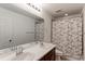 Bathroom with a double vanity, modern fixtures, and a shower with stylish curtain at 9835 Uravan St, Commerce City, CO 80022