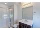Neutral bathroom featuring a shower with glass door and a dark wood vanity at 9835 Uravan St, Commerce City, CO 80022
