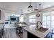 Open kitchen and living area featuring a large island and modern lighting fixtures at 9835 Uravan St, Commerce City, CO 80022