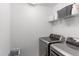 Modern laundry room with side-by-side washer and dryer on display at 9835 Uravan St, Commerce City, CO 80022
