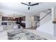 Open-concept living room with plush sofa, modern rug, and view of the adjacent kitchen and staircase at 9835 Uravan St, Commerce City, CO 80022
