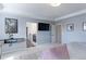 Bright main bedroom shows a mounted TV, light grey paint and an ensuite bath at 9835 Uravan St, Commerce City, CO 80022