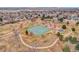 Aerial view of a neighborhood park featuring tennis courts, walking paths, and playground equipment at 6133 Uno St, Arvada, CO 80003