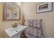 Charming powder room with pedestal sink, decorative towels, ornate mirror, and neutral wall color at 22683 Hagler Dr, Golden, CO 80401