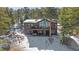 Spacious brown house nestled in a snowy forest with a deck and large windows offering scenic views at 22683 Hagler Dr, Golden, CO 80401