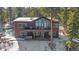 Rear exterior view of two-story home featuring a hot tub, large windows, and a spacious deck with mountain views at 22683 Hagler Dr, Golden, CO 80401