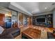 Finished basement boasts an entertainment area with a large TV, a plush ottoman, and hardwood floors at 22683 Hagler Dr, Golden, CO 80401