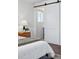 Bright bedroom with wood floors, a plush bed, and a sliding door leading to a bathroom for convenience at 12345 W 32Nd Ave, Wheat Ridge, CO 80033