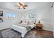 Bright bedroom featuring wood floors, a plush bed with throw pillows, and windows providing natural light at 12345 W 32Nd Ave, Wheat Ridge, CO 80033