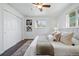 Bright bedroom featuring wood floors, a plush bed with throw pillows, and a closet with sliding doors at 12345 W 32Nd Ave, Wheat Ridge, CO 80033