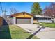 Lovely single story home with an attached garage, wooden accents, a lush lawn, and a long driveway at 12345 W 32Nd Ave, Wheat Ridge, CO 80033