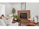 Cozy living room featuring a brick fireplace, comfortable seating, and stylish decor at 12345 W 32Nd Ave, Wheat Ridge, CO 80033