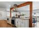 Modern kitchen featuring stainless steel appliances and vent hood, bright lighting, and wood beam accents at 12345 W 32Nd Ave, Wheat Ridge, CO 80033