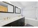 Bright bathroom with marble countertops, double vanity, and bathtub with shower at 23558 Pondview Pl # B, Golden, CO 80401