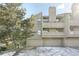 Townhome with garage parking and exterior view surrounded by trees, and winter landscape at 23558 Pondview Pl # B, Golden, CO 80401