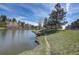 Beautiful pond with grassy shoreline and path, creating a peaceful natural environment at 23558 Pondview Pl # B, Golden, CO 80401