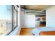 Bright bedroom features hardwood floors, exposed ductwork, and expansive windows with city views at 1401 Wewatta St # 808, Denver, CO 80202