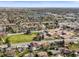 Expansive aerial view showcasing the neighborhood, a nearby lake, and mature trees at 9940 Pecos St, Thornton, CO 80260