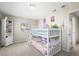 Bright bedroom featuring a white bunk bed, shelving, and natural light from a window at 9940 Pecos St, Thornton, CO 80260