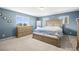 Serene primary bedroom showcasing blue walls, two windows and wood furniture at 9940 Pecos St, Thornton, CO 80260