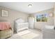 Cozy bedroom featuring white furniture including a crib and changing table at 9940 Pecos St, Thornton, CO 80260