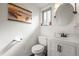 Clean half bathroom featuring a white vanity, toilet, and a decorative round mirror at 9940 Pecos St, Thornton, CO 80260