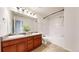 Bathroom featuring double sink vanity, white tile, bathtub, and neutral walls at 12783 Leyden St # E, Thornton, CO 80602