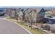 Aerial view of multi-story townhouses in a neighborhood near a pond and green space at 12783 Leyden St # E, Thornton, CO 80602