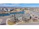 Aerial view of a multi-story townhouse with beautiful landscaping, a nearby pond, playground, and mountain views at 12783 Leyden St # E, Thornton, CO 80602