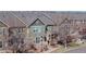 Street-level view of townhome units with well-maintained lawns and mature landscaping; bare trees give winter feel at 12783 Leyden St # E, Thornton, CO 80602