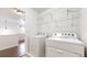 Well-lit laundry room featuring a white washer and dryer with wire shelving above for convenient storage at 12783 Leyden St # E, Thornton, CO 80602