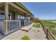 Back porch with decorative rock, landscaping, wood fence, and grass, providing an inviting outdoor space at 6614 Club Villa Rd, Parker, CO 80134