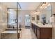 Open bathroom featuring a double vanity, glass shower, and a view into the bedroom at 6614 Club Villa Rd, Parker, CO 80134