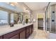 Bathroom with a double vanity, large mirror, and glass shower with tile surround at 6614 Club Villa Rd, Parker, CO 80134