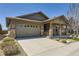 Charming home with a two-car garage, stone accents, well-manicured landscaping, and a covered front porch at 6614 Club Villa Rd, Parker, CO 80134