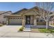 Charming home with a two-car garage, stone accents, and a welcoming front porch at 6614 Club Villa Rd, Parker, CO 80134