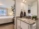 Bathroom with granite countertops, an updated mirror, and a partial view into the Primary bedroom at 18270 E 51St Pl, Denver, CO 80249