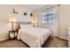 Comfortable bedroom featuring a plush bed, soft lighting, and large window with blinds at 18270 E 51St Pl, Denver, CO 80249
