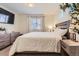 Comfortable bedroom featuring a queen-sized bed, soft lighting, and a large window with blinds at 18270 E 51St Pl, Denver, CO 80249