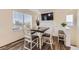 Bright dining area with wood floors, modern table, and a large window for plenty of natural light at 18270 E 51St Pl, Denver, CO 80249