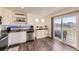 Well-lit kitchen featuring white cabinets, stainless steel appliances, and a sliding glass door leading to outdoor living space at 18270 E 51St Pl, Denver, CO 80249