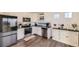 Bright kitchen with white cabinets, stainless steel appliances, granite countertops, and warm-toned luxury vinyl flooring at 18270 E 51St Pl, Denver, CO 80249